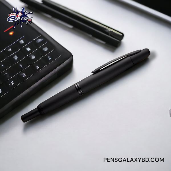 Pilot Vanishing Point Fountain Pen in Matte Black - 18K Gold - On a white desk with a laptop image