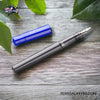 Pilot Kakuno Fountain Pen - Blue/Gray - On a desk with tree leaf image