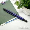 Pilot Vanishing Point Fountain Pen - Matte Blue - On a white Ikea desk on top of a green diary beside is a flower top